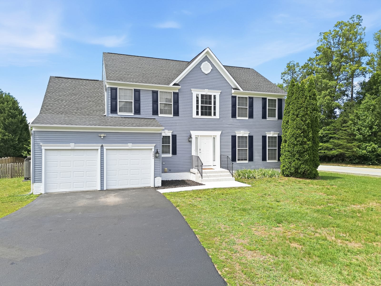 Front of the home with the driveway and garage doors